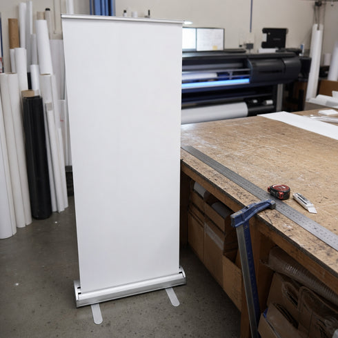 Graphictac 10mil anti-curl roll-up banner media prepared for retail display signage in a print shop